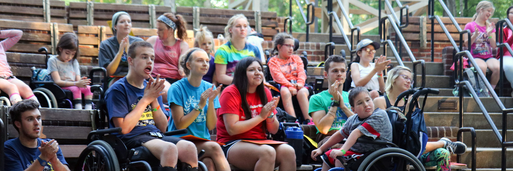 Smiling campers and staff members sitting in the amphitheater.